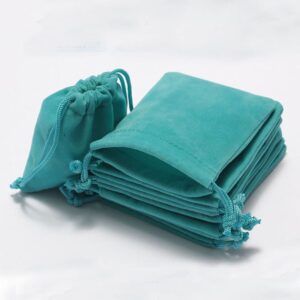 A stack of customizable teal blue velvet drawstring pouches ideal for luxury jewelry packaging and small gifts.