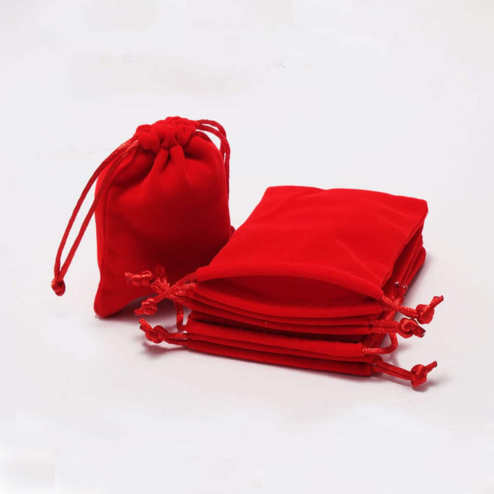 High-quality crimson red velvet drawstring gift bags stacked neatly for custom logo printing and retail packaging.