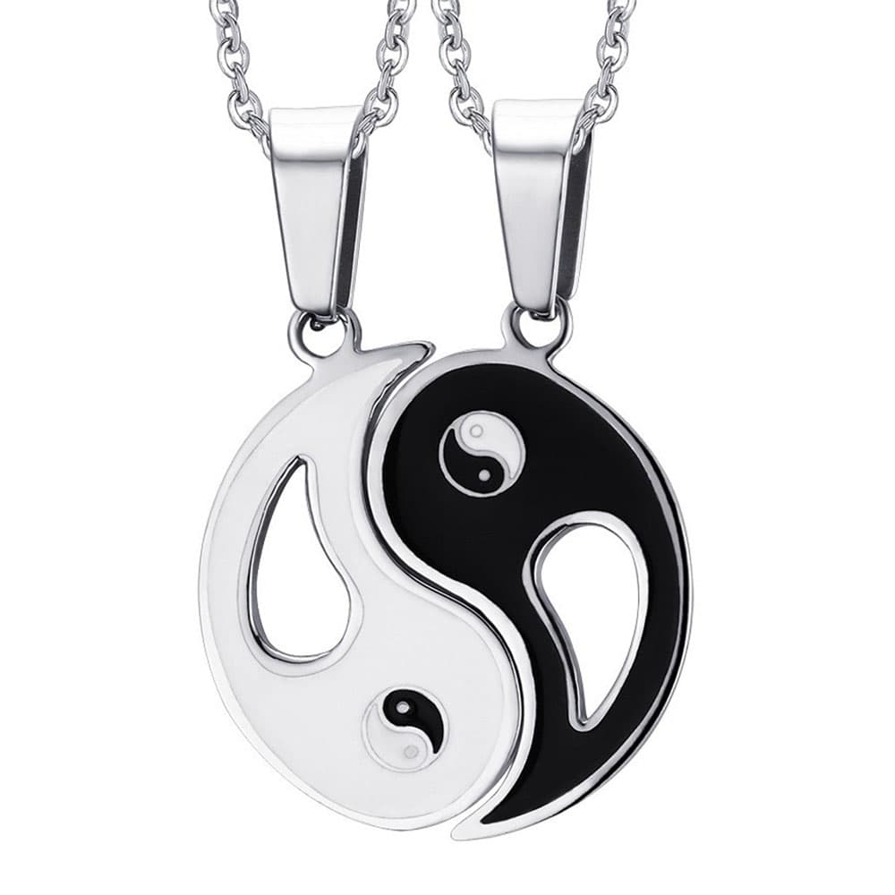 Two matching silver-tone stainless steel Yin Yang puzzle pendant necklaces for couples, one side in white enamel and the other in black enamel.