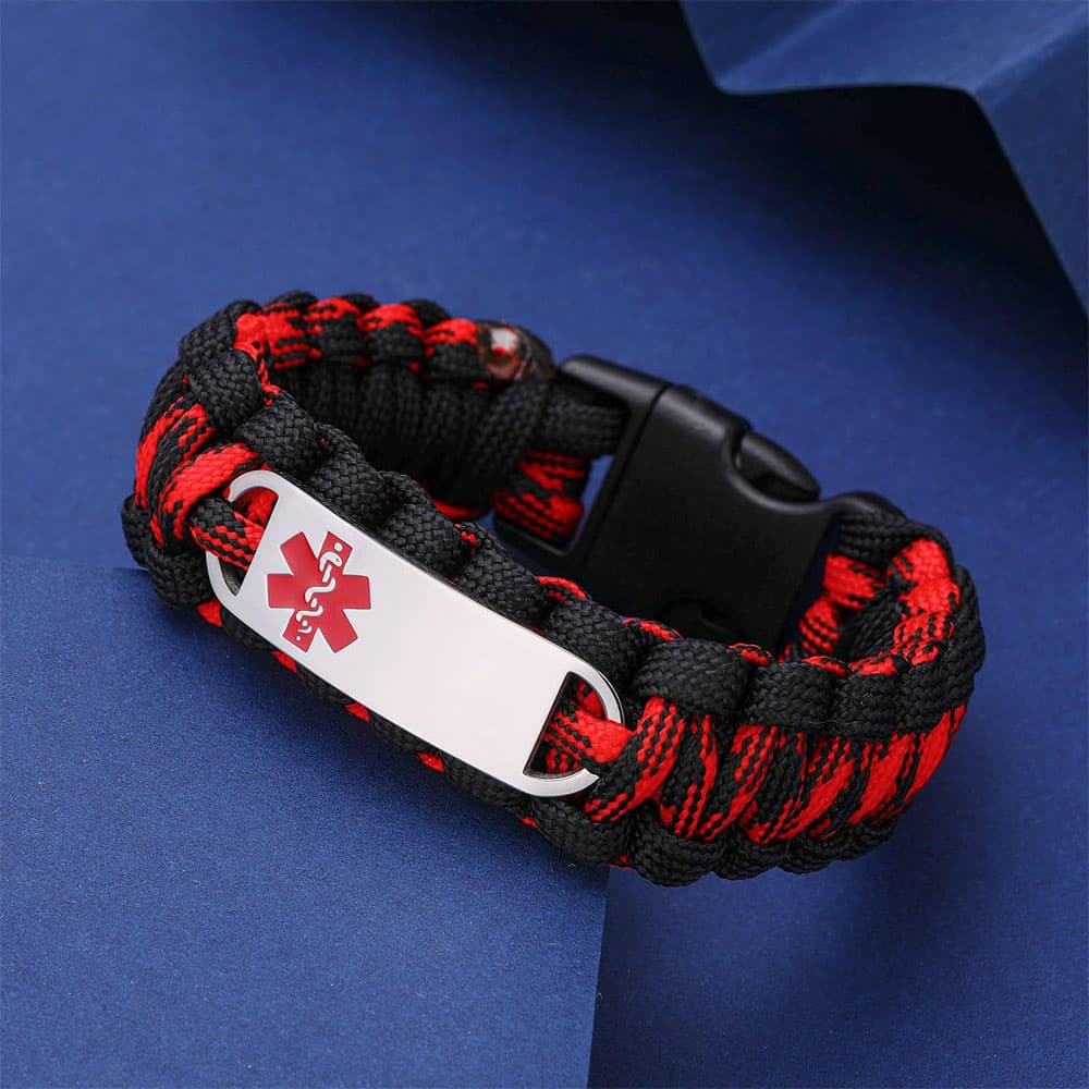 Engravable stainless steel medical alert ID plate on black and red woven paracord bracelet displayed on a blue background.