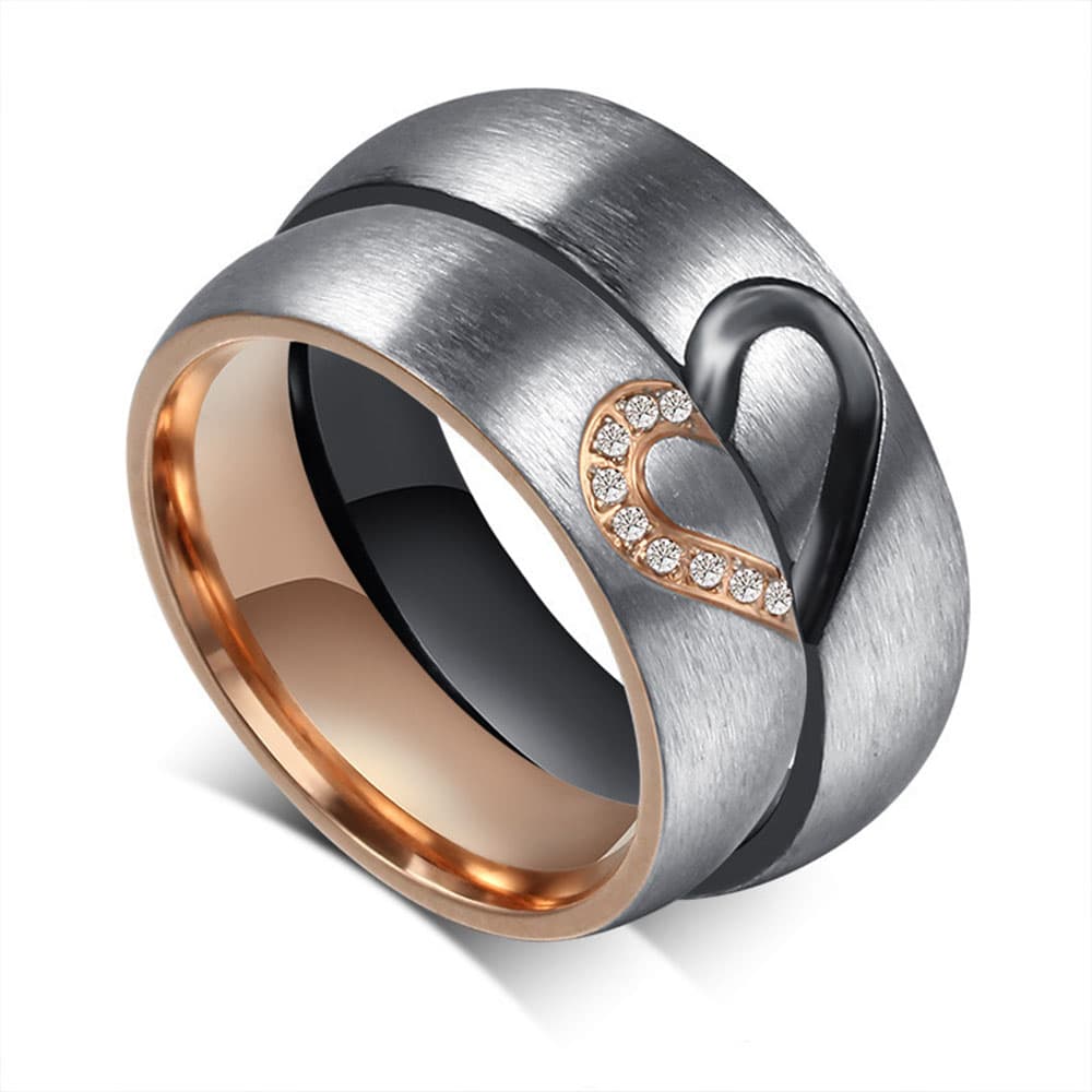 Close-up of two matching stainless steel couple bands aligned together to form a complete heart shape with cubic zirconia detail.